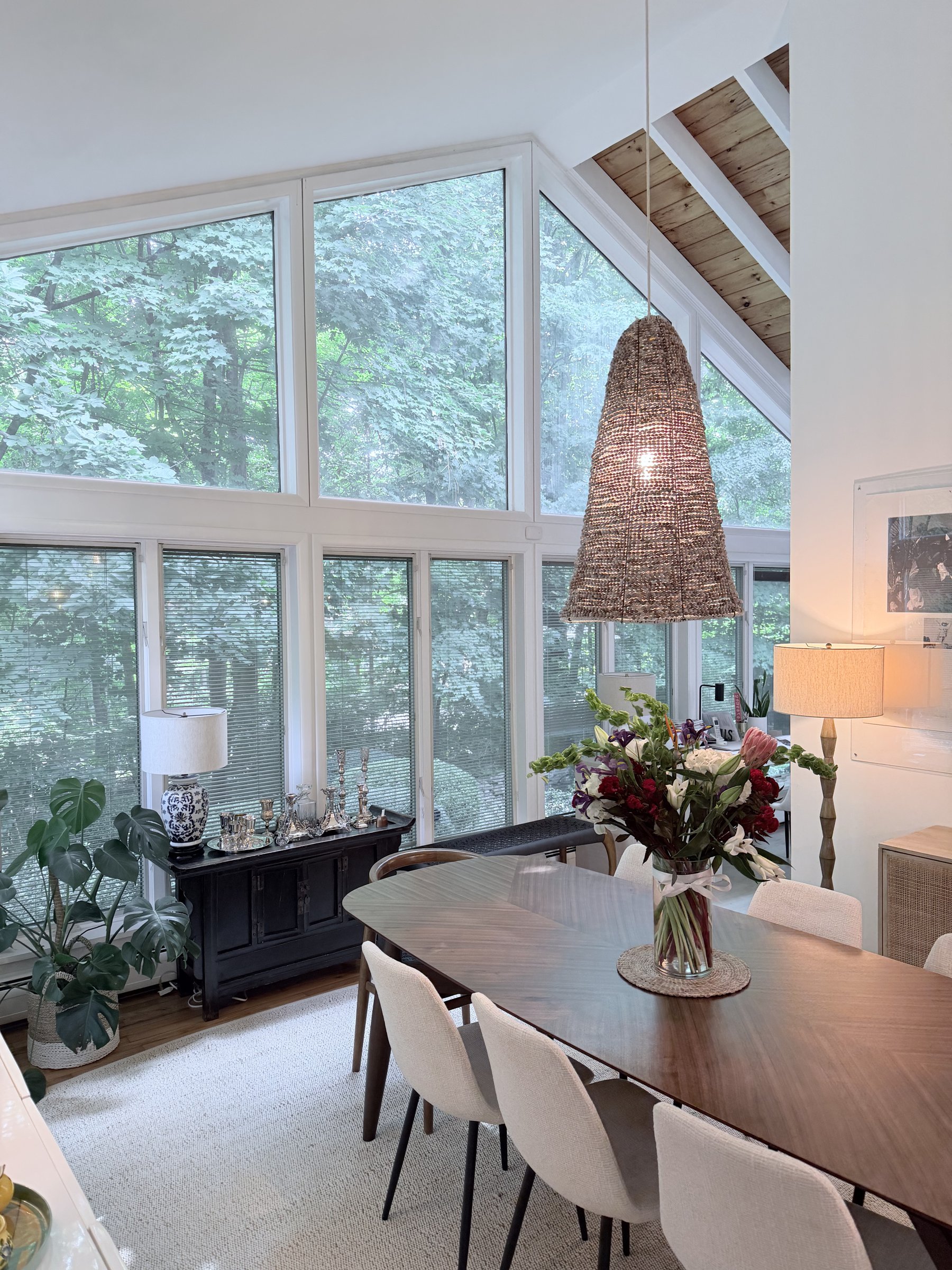 Dining room with tall windows looking into the trees