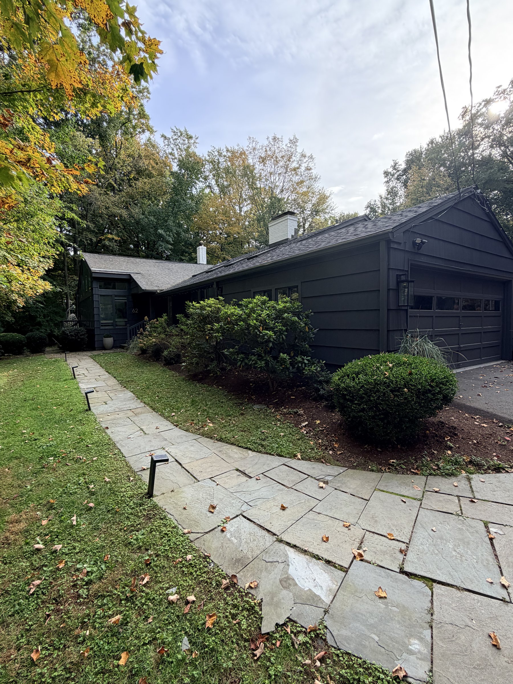 Stone path curving toward the dark house under trees